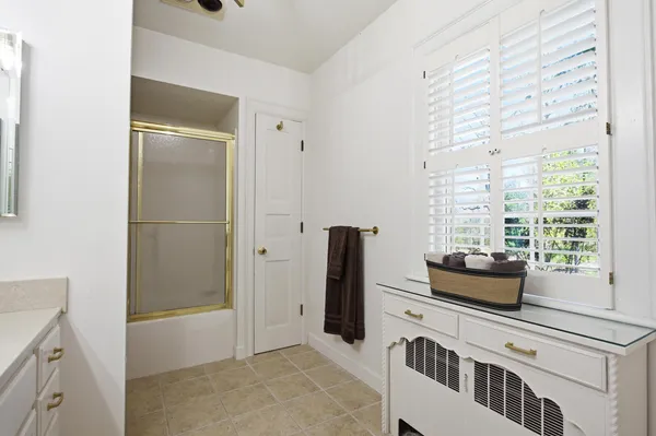 a bathroom with a granite countertop toilet a sink and a mirror