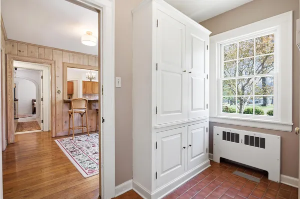 a utility room with stainless steel appliances wooden floors and white walls