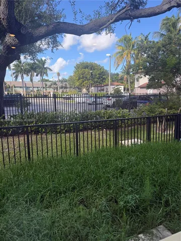 a view of a kitchen with refrigerator and white cabinets
