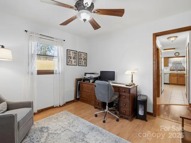 a view of a workspace with furniture and a window