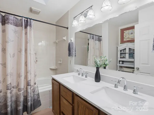 a bathroom with a double vanity sink mirror and shower