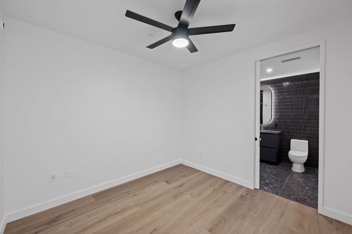 610 Davis Street, Unit 4308 Austin, TX 78701 - Photo 11 of 21 a view of a room with wooden floor and a ceiling fan