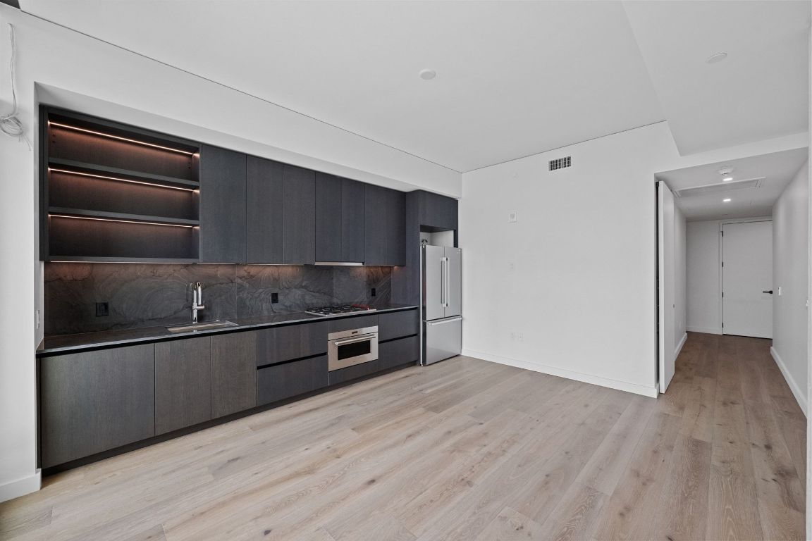 610 Davis Street, Unit 4308 Austin, TX 78701 - Photo 7 of 21 a kitchen with granite countertop a stove and a refrigerator
