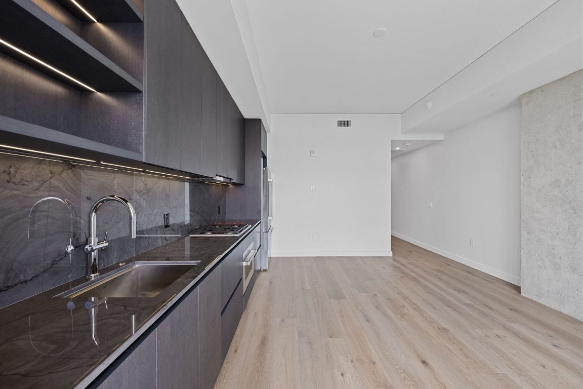 610 Davis Street, Unit 4308 Austin, TX 78701 - Photo 8 of 21 a kitchen with stainless steel appliances granite countertop a sink and wooden floors