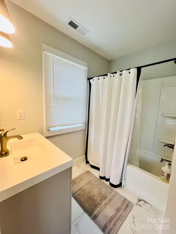 a spacious bathroom with a double vanity sink toilet and shower