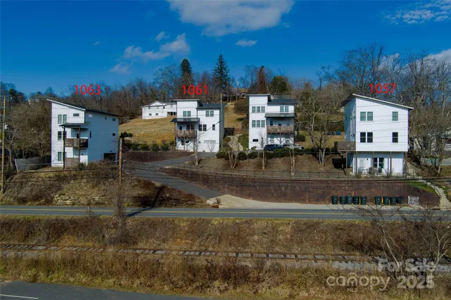 a kitchen with a refrigerator a stove top oven a sink dishwasher and white cabinets with wooden floor