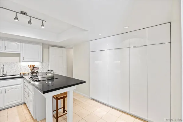 a kitchen with white cabinets and sink
