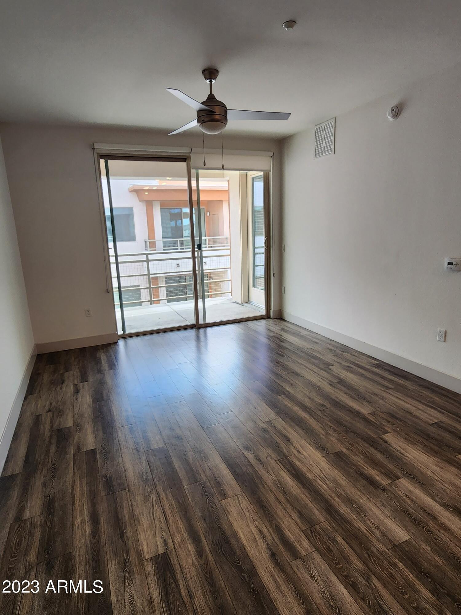 250 East Ray Road, Unit 2 Chandler, AZ 85225 - Photo 2 of 16 a view of an empty room with wooden floor and a window