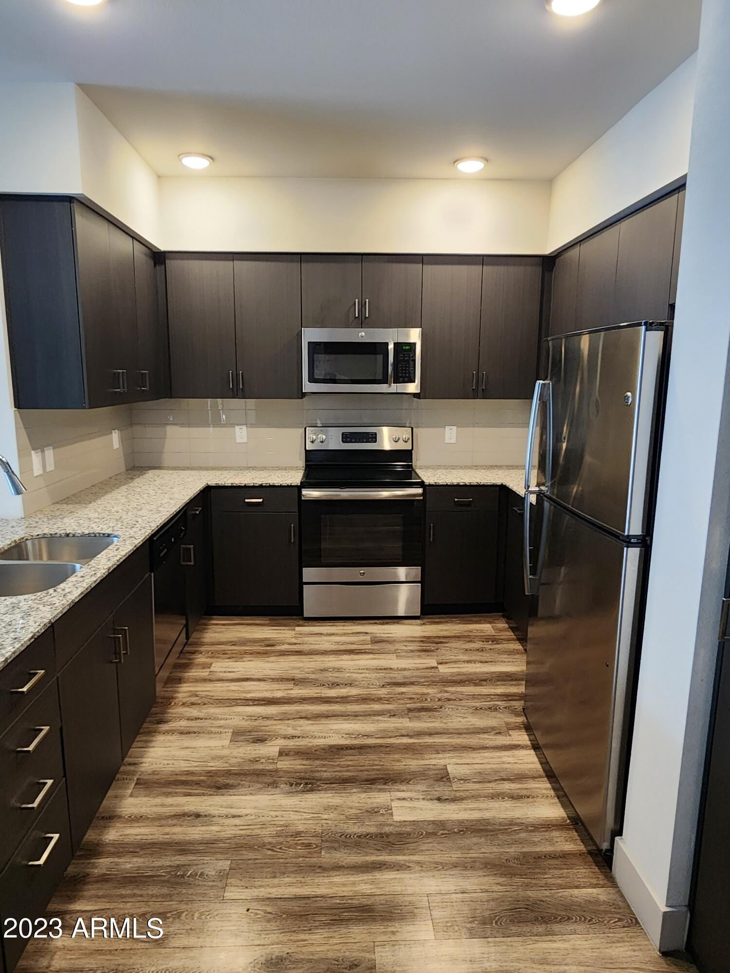 250 East Ray Road, Unit 2 Chandler, AZ 85225 - Photo 3 of 16 a large kitchen with granite countertop a stove and a sink