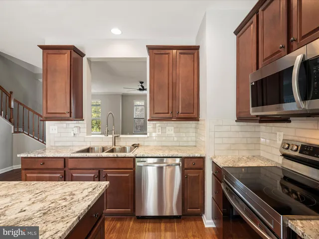 a kitchen with stainless steel appliances granite countertop a sink stove and microwave