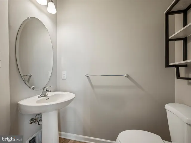 a bathroom with a sink mirror and toilet