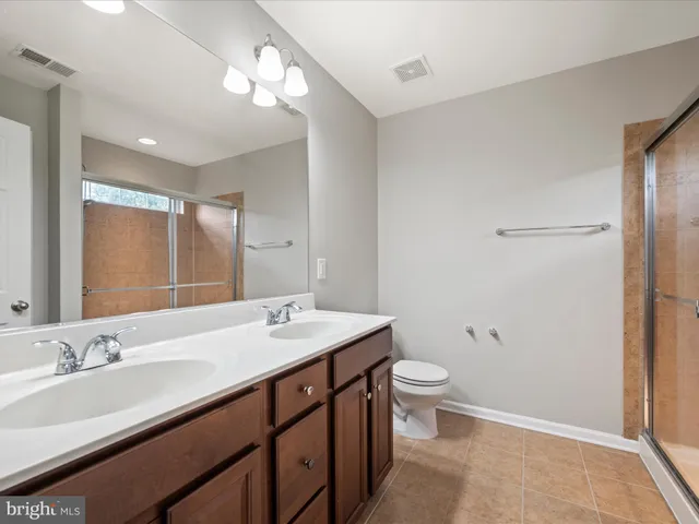 a bathroom with a double vanity sink toilet and a mirror