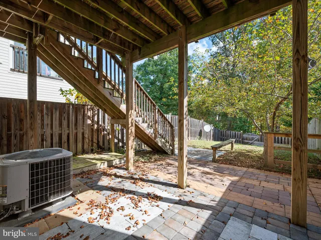 a view of a patio with a table chairs and wooden fence