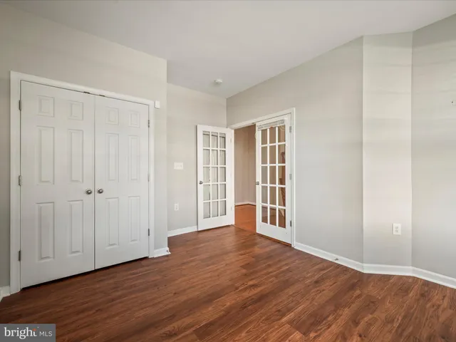 a view of an empty room with wooden floor and entryway