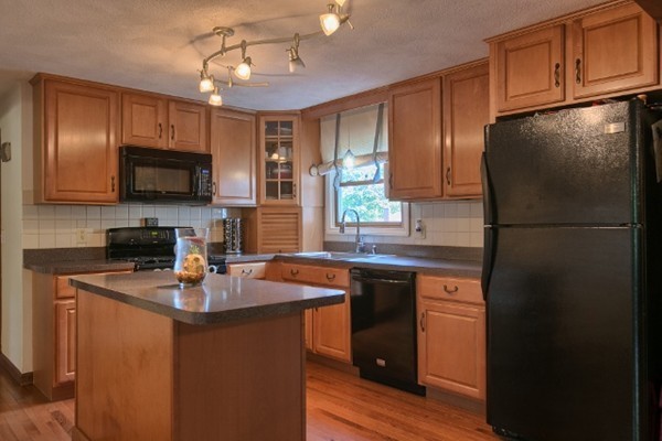 42 Emery Road Townsend, MA 01469 - Photo 10 of 30 a kitchen with stainless steel appliances granite countertop a refrigerator a sink a stove a microwave and wooden cabinets