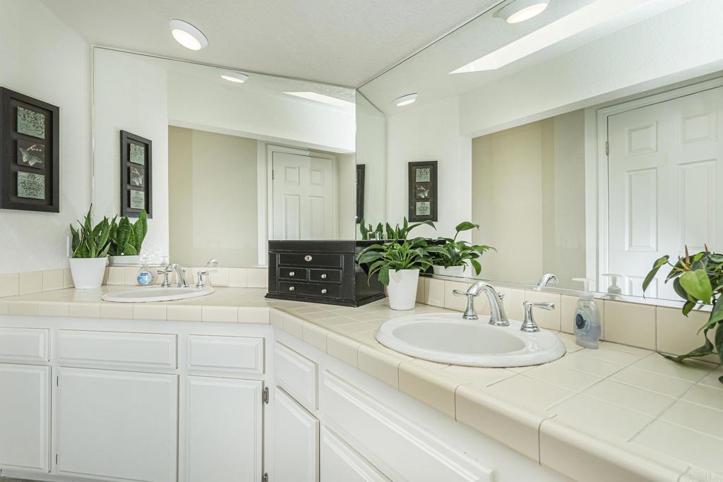 656 Westlake Street Encinitas, CA 92024 - Photo 27 of 41 a bathroom with a granite countertop sink and a mirror