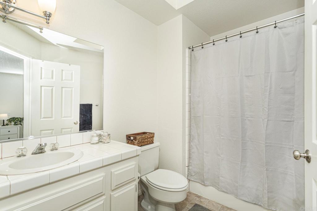 656 Westlake Street Encinitas, CA 92024 - Photo 30 of 41 a bathroom with a sink a toilet a mirror and shower curtain