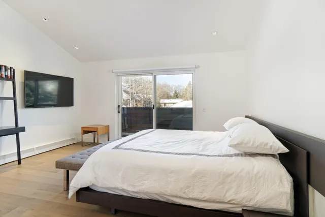 a bedroom with a bed tv and a window