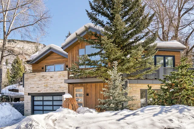 a view of a white house with a large tree