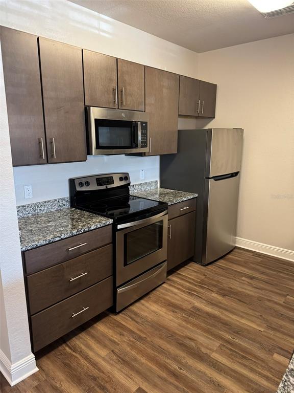 2460 Ann Rou Road, Unit 606 Tavares, FL 32778 - Photo 3 of 18 a kitchen with stainless steel appliances granite countertop a refrigerator and a stove