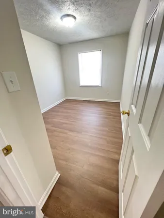 view of an empty room with wooden floor and a window