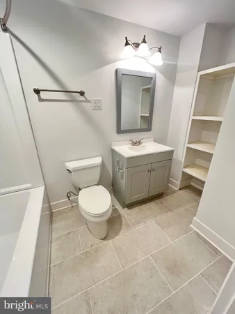 a bathroom with a toilet mirror and vanity