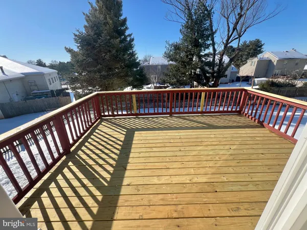 a view of balcony with wooden floor and fence and trees