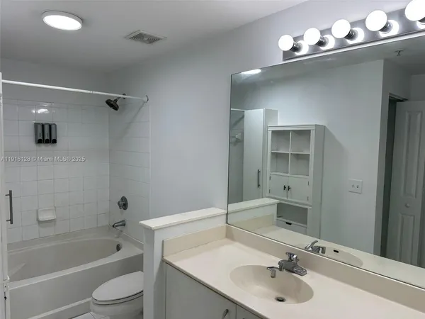 a bathroom with a tub sink and mirror