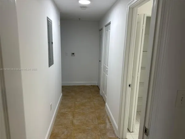 a view of a hallway with wooden floor and a bathroom