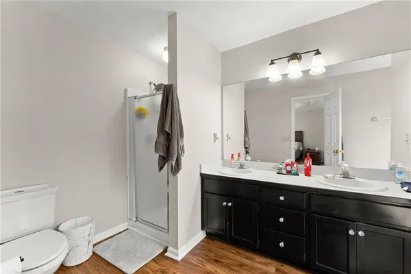 a bathroom with a toilet sink double vanity and mirror