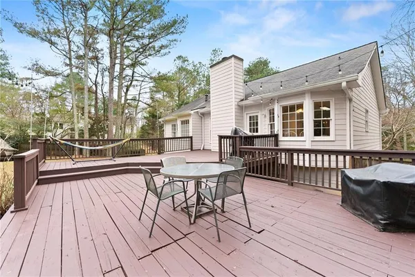 a view of a house with wooden deck and outdoor seating