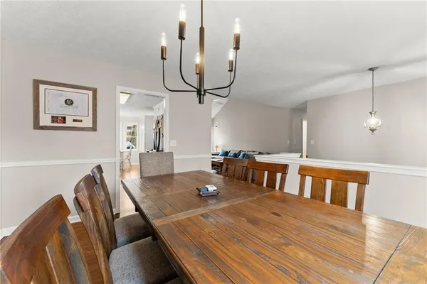 a living room with furniture a chandelier and a wooden floor