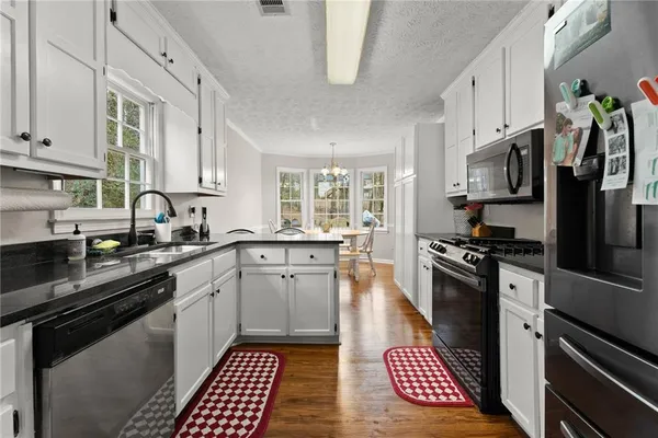 a kitchen with stainless steel appliances granite countertop a stove sink and cabinets