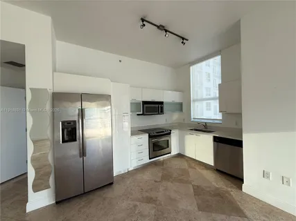 a large kitchen with a refrigerator and a stove top oven