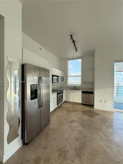 a view of a kitchen with a sink and refrigerator