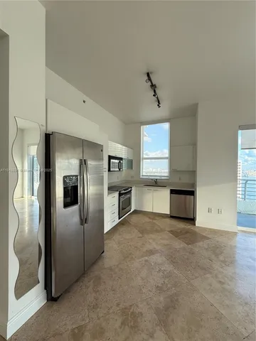 a view of a kitchen with a sink and refrigerator