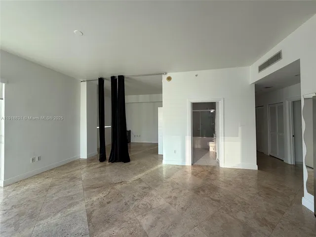 an empty room with closet and a bathroom