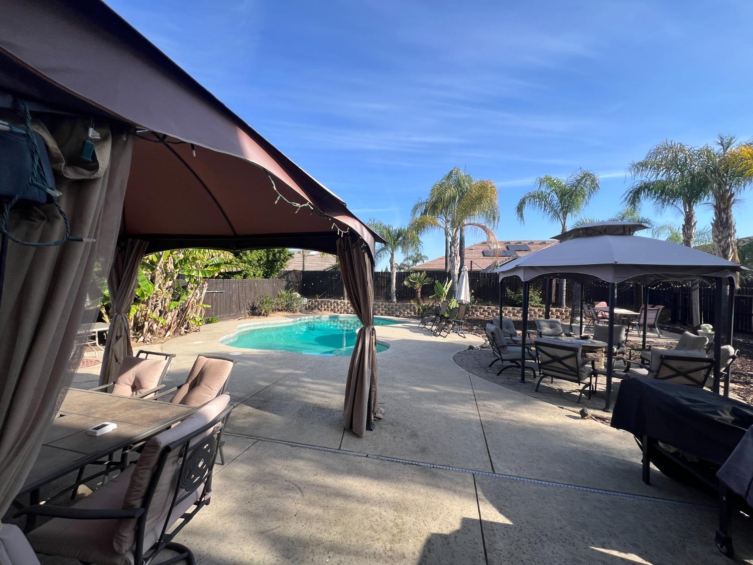 2653 Ashcroft Avenue Clovis, CA 93611 - Photo 30 of 45 a patio with a table and chairs under an umbrella
