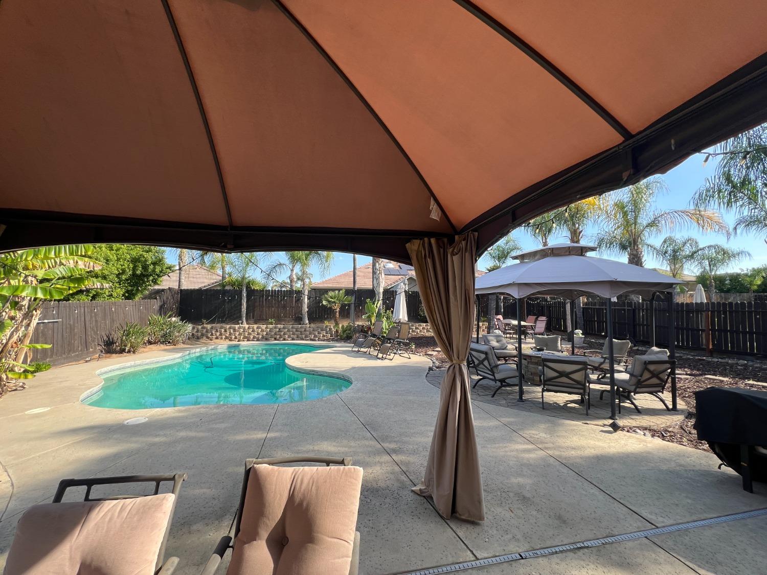 2653 Ashcroft Avenue Clovis, CA 93611 - Photo 31 of 45 a patio with a table and chairs under an umbrella