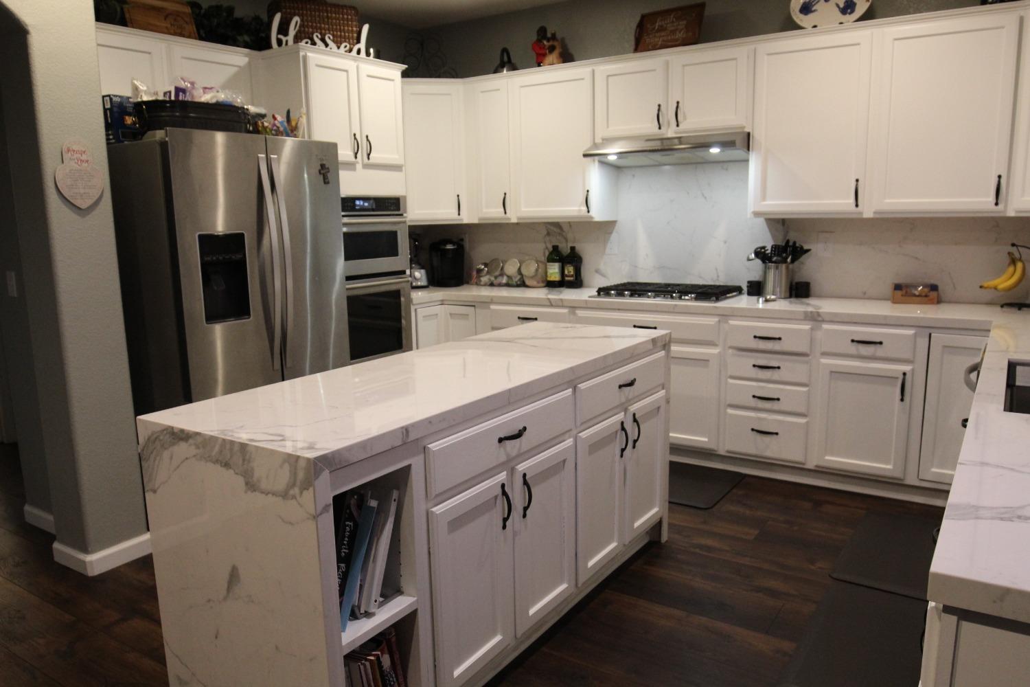 2653 Ashcroft Avenue Clovis, CA 93611 - Photo 9 of 45 a kitchen with stainless steel appliances a sink stove refrigerator and cabinets