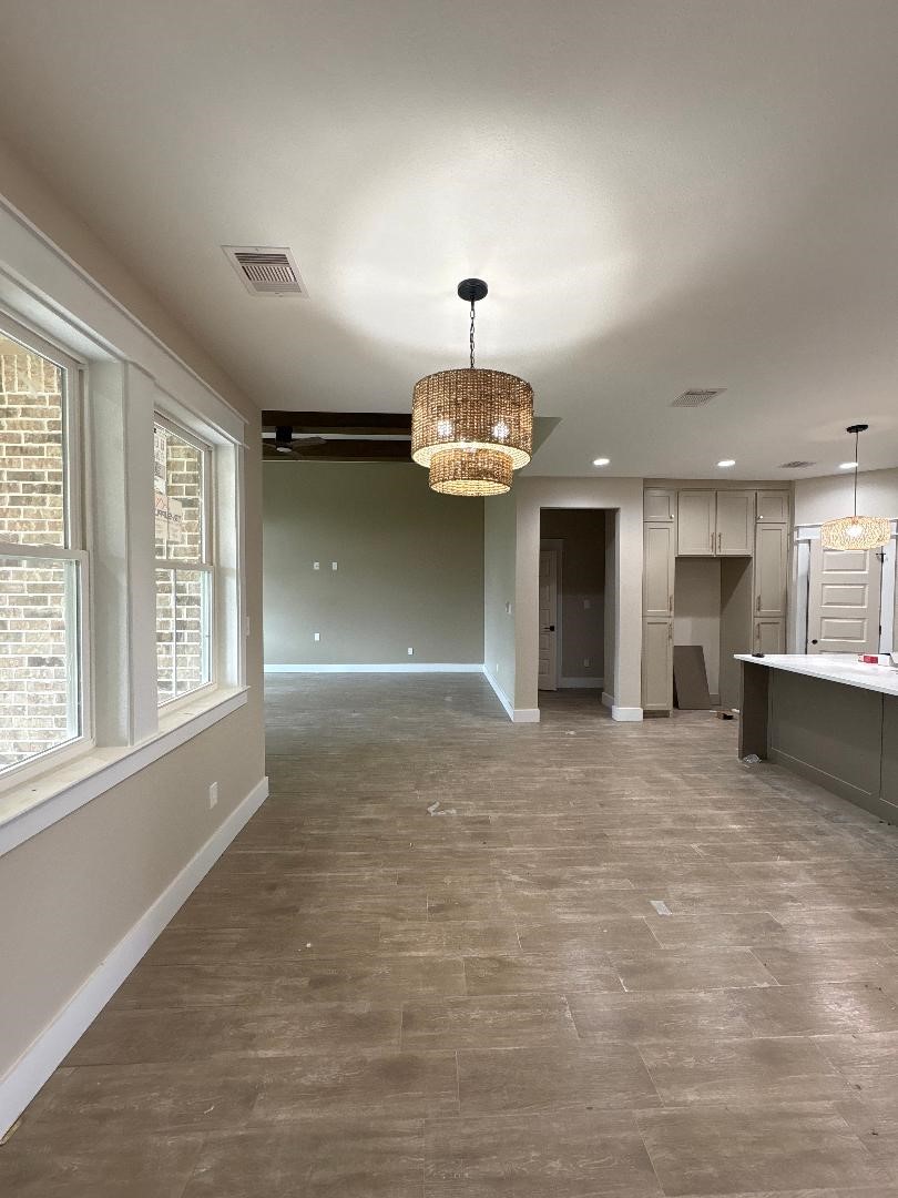 5680 Essie Lane Beaumont, TX 77713 - Photo 6 of 22 an empty room with a kitchen and a chandelier
