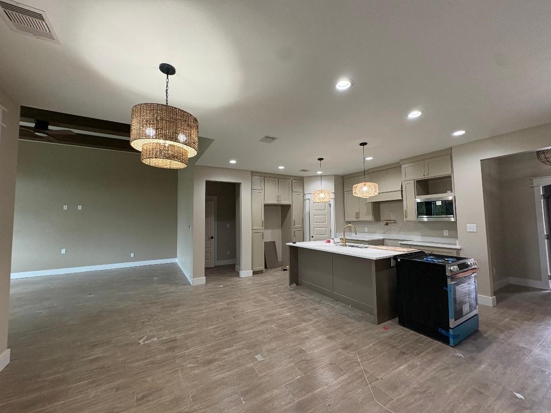 5680 Essie Lane Beaumont, TX 77713 - Photo 7 of 22 a large kitchen with kitchen island a sink stainless steel appliances and cabinets
