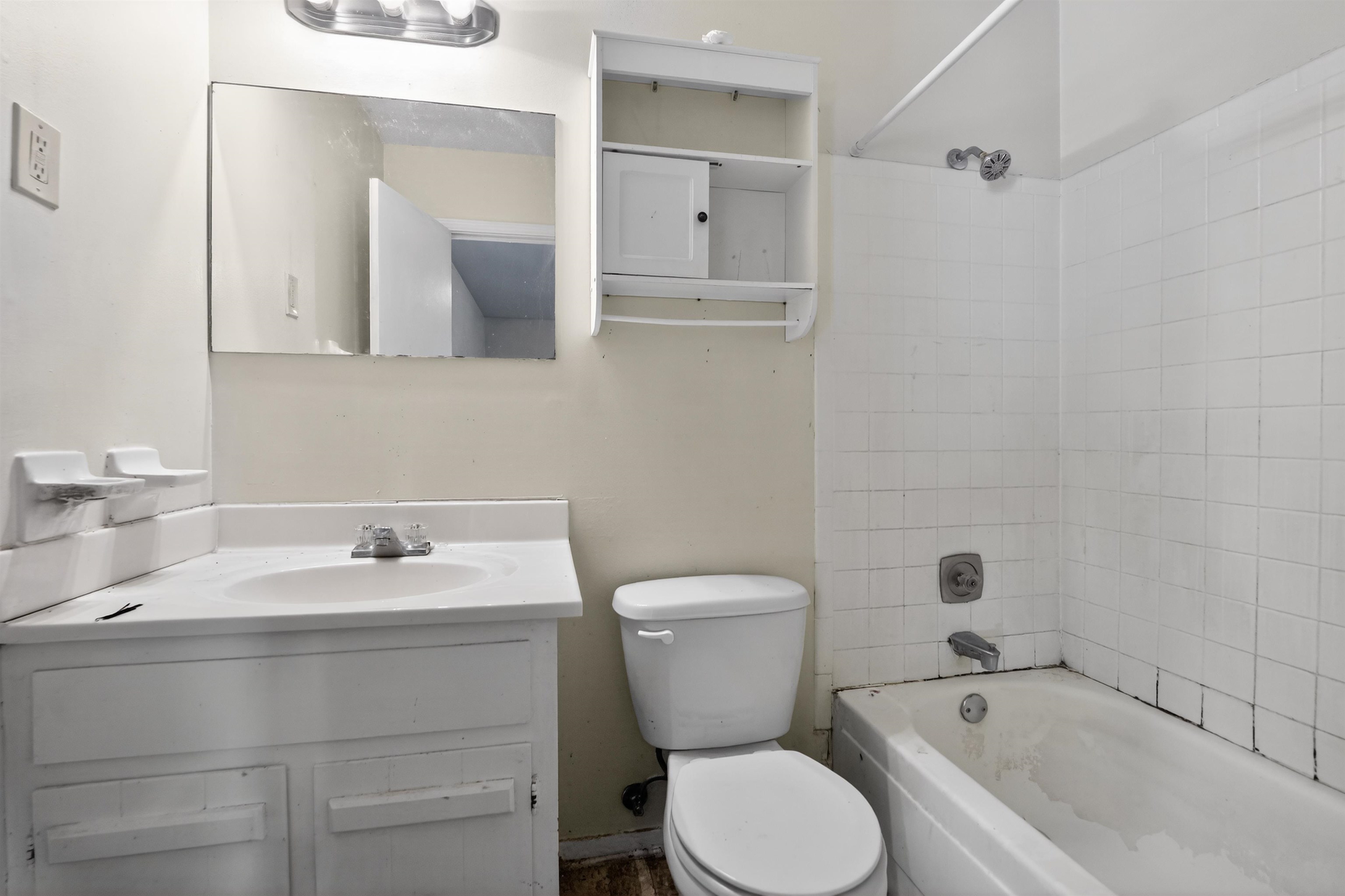 3372 Spring Shadow Drive Memphis, TN 38118 - Photo 30 of 35 Bathroom featuring a white vanity with integrated sink, wall-mounted mirror, white toilet, and a white tiled shower-tub combination