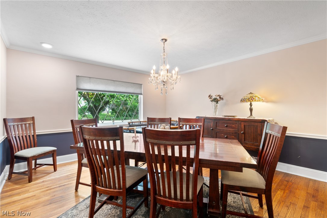 443 Merriman Road Akron, OH 44303 - Photo 10 of 44 Spacious room featuring wood-finish flooring, a crystal chandelier, recessed lighting, and a decorative window with diamond-patterned grilles