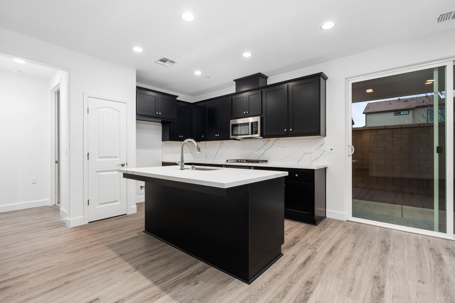 380 South Huckleberry Road Madera, CA 93636 - Photo 4 of 15 a kitchen with kitchen island granite countertop a sink and a stove top oven with wooden floor