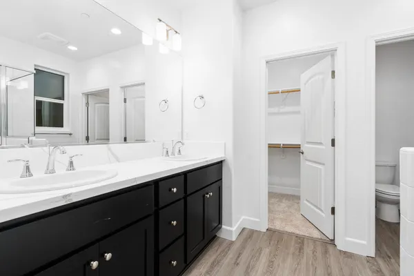 a bathroom with a double vanity sink a mirror and a shower