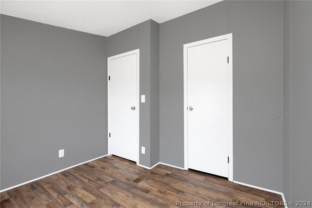 152 Three Bridges Road Rowland, NC 28383 - Photo 5 of 27 an empty room with wooden floor and closet