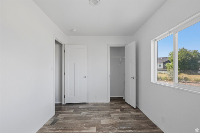433 North 750 West Logan, UT 84321 - Photo 14 of 40 Interior space featuring light gray walls, wood-finish flooring, a white trim window, a white interior door, and an open closet with wire shelving