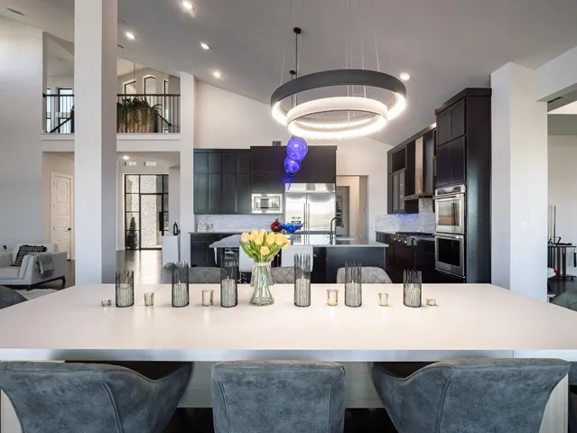 a kitchen with stainless steel appliances kitchen island granite countertop a table chairs and a refrigerator