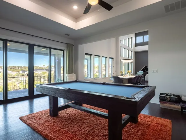a dining hall with couches a coffee table and a stove with wooden floor